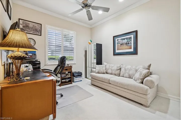 Carpeted office featuring crown molding and ceiling fan