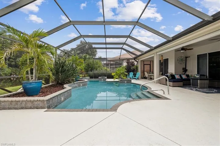 View of pool with a patio, glass enclosure, an outdoor hangout area, and ceiling fan