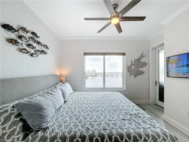 Bedroom with ornamental molding, multiple windows, ceiling fan, and hardwood / wood-style floors