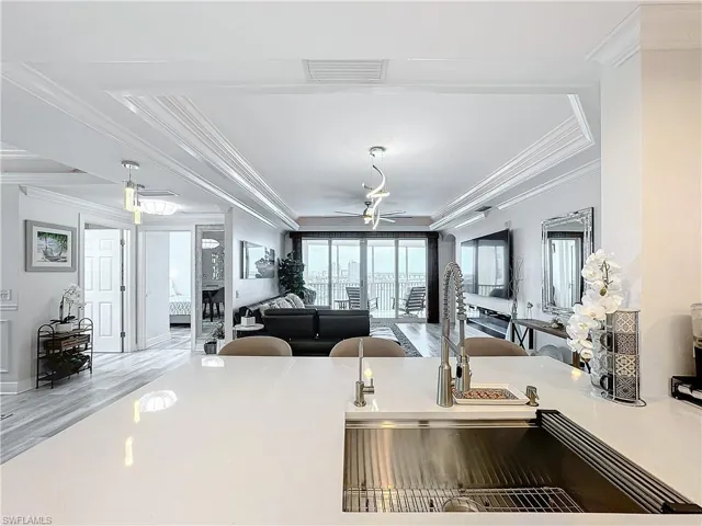 Kitchen featuring ceiling fan, a tray ceiling, light hardwood / wood-style flooring, and ornamental molding