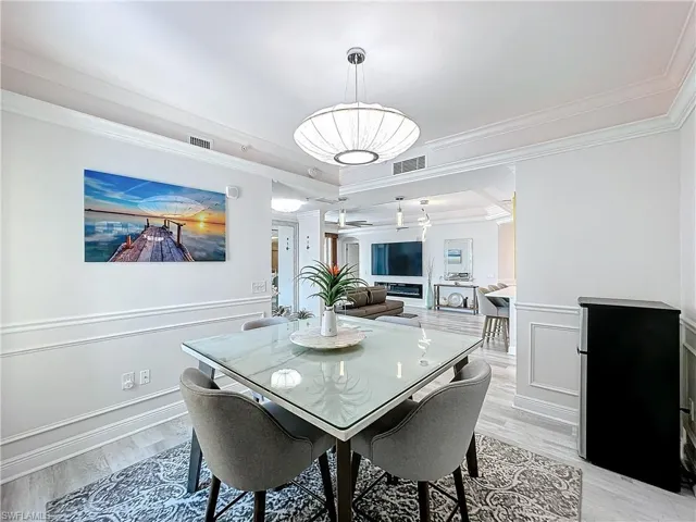 Dining space featuring crown molding, light hardwood / wood-style flooring, and a tray ceiling