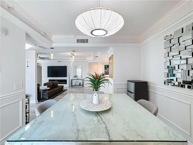 Dining area featuring ornamental molding, a raised ceiling, and hardwood / wood-style floors