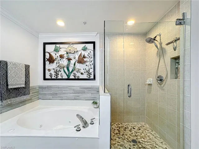 Bathroom featuring independent shower and bath and crown molding