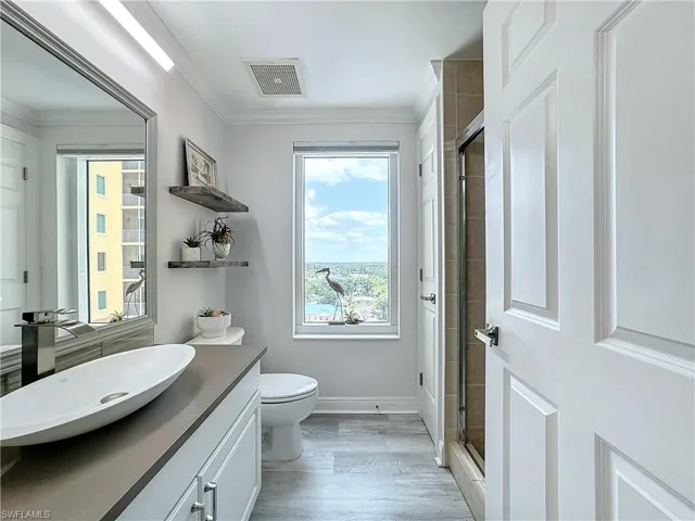 Bathroom featuring an enclosed shower, toilet, vanity, hardwood / wood-style floors, and ornamental molding