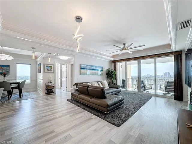 Living room with light hardwood / wood-style flooring, crown molding, and ceiling fan