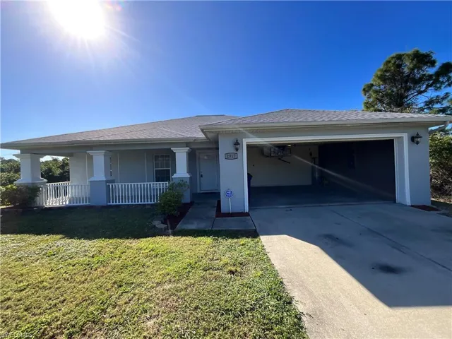 Single story home with a front yard, a porch, and a garage
