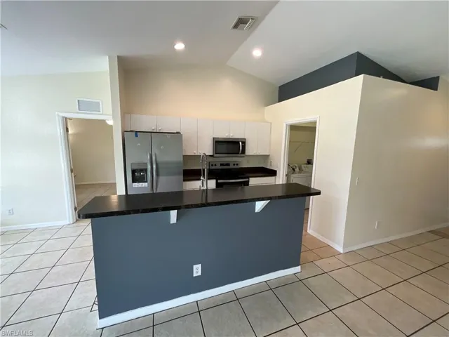 Kitchen with stainless steel appliances, island with sink.