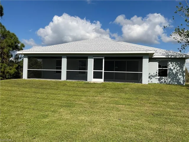 Rear view of property featuring a lawn.