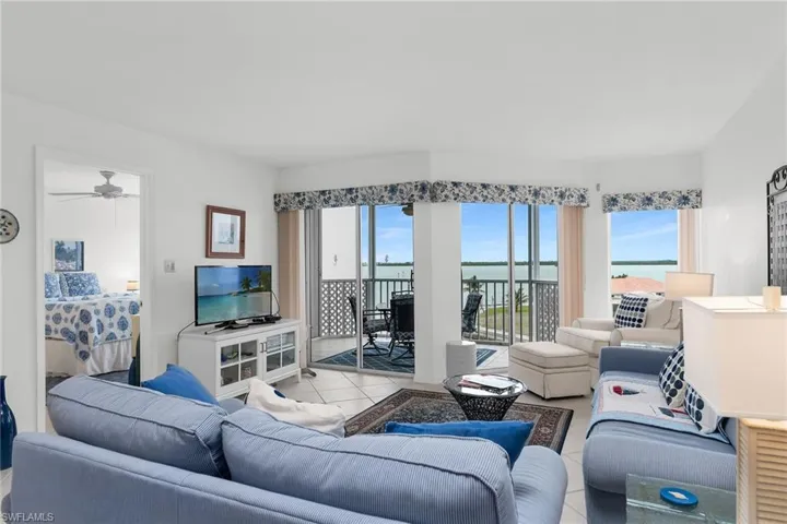 Living room featuring light tile patterned flooring and a ceiling fan