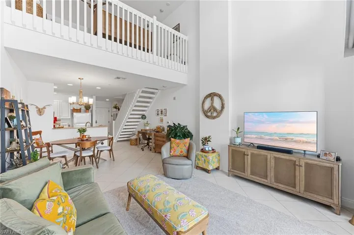 Open-concept living area with soaring ceilings and a loft overlooking the space