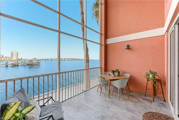 Expansive screened balcony featuring floor-to-ceiling windows, water frontage, and tile flooring