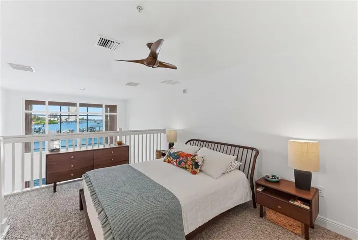 Loft-style room featuring light-toned carpeting and white walls