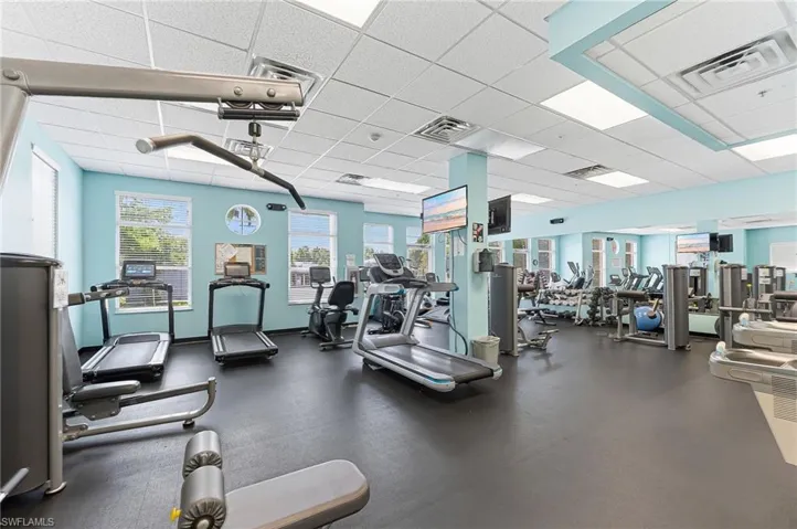 Spacious fitness center featuring rubber flooring and light blue walls