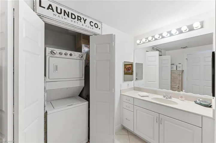 Laundry in closet in master bathroom and bathroom sink, mirror