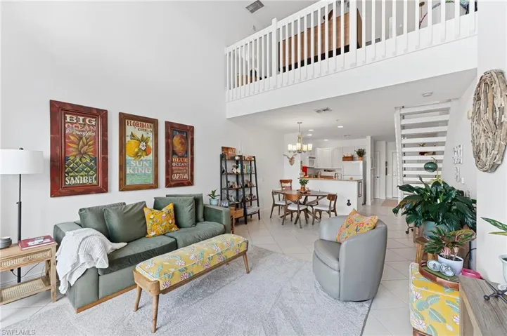 Living area featuring a high ceiling, white walls, and light-toned tile flooring