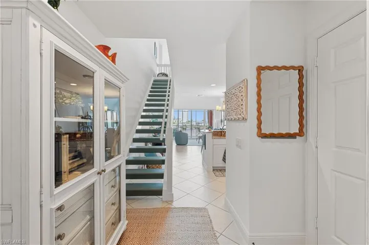Entryway featuring a white cabinet with glass doors and drawer storage