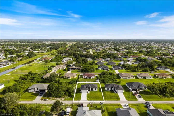 Aerial view of residential area with a large body of water and property boundaries highlighted