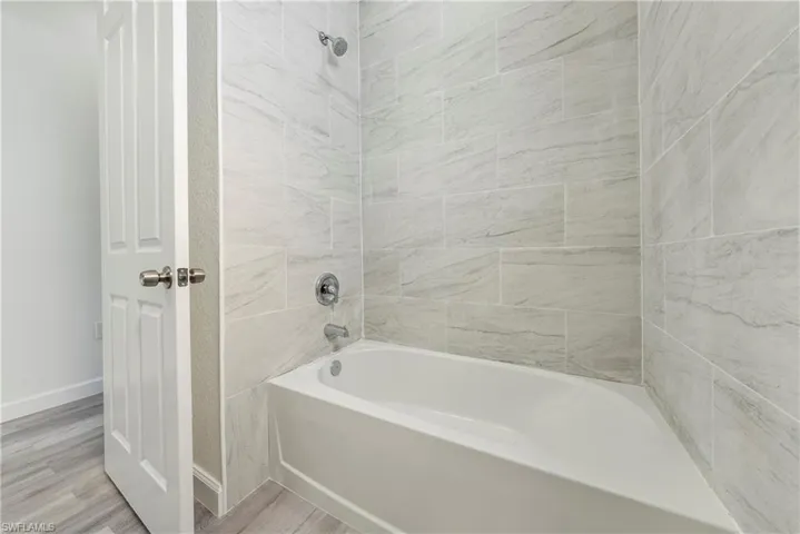 Full bathroom with wood finished floors and shower / bath combination