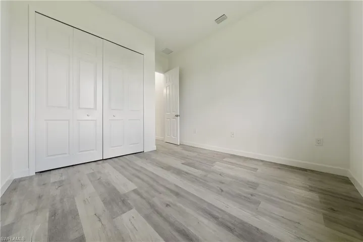 Unfurnished bedroom with light wood-style flooring and a closet