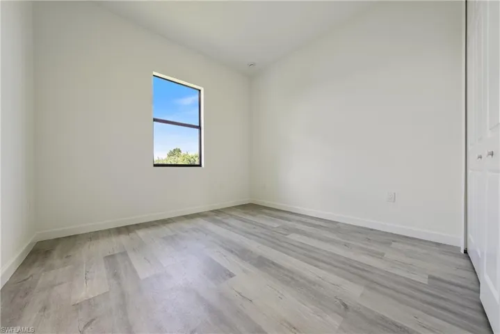 Unfurnished bedroom with light wood finished floors and baseboards