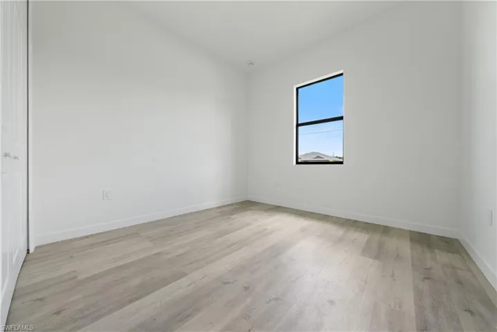 Unfurnished room featuring light wood-type flooring and baseboards