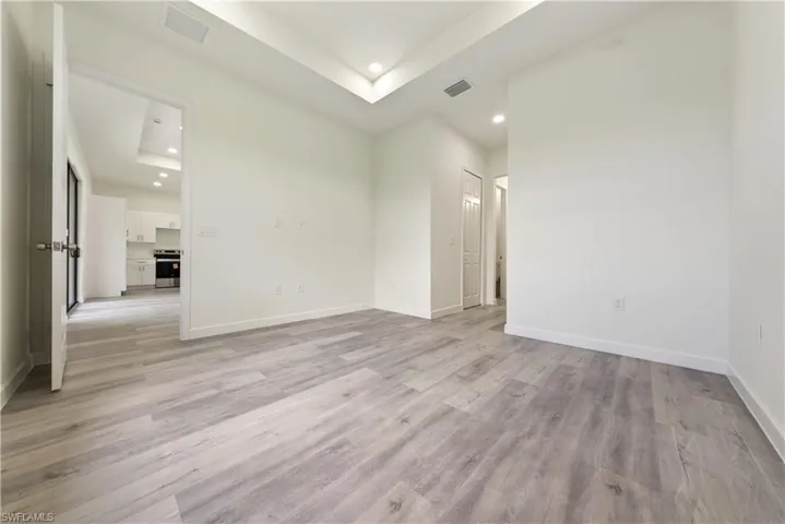 Unfurnished room featuring recessed lighting, a raised ceiling, and light wood-style flooring