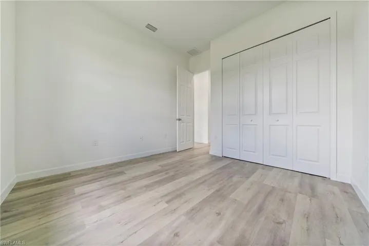 Unfurnished bedroom featuring light wood finished floors and a closet