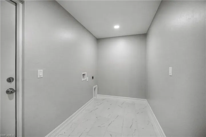 Laundry area with light marble finish floors, electric dryer hookup, hookup for a washing machine, and recessed lighting