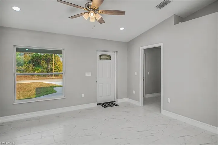 Foyer with light marble finish floors, a ceiling fan, recessed lighting, and vaulted ceiling