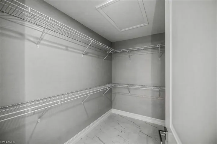 Walk in closet with light marble finish floors