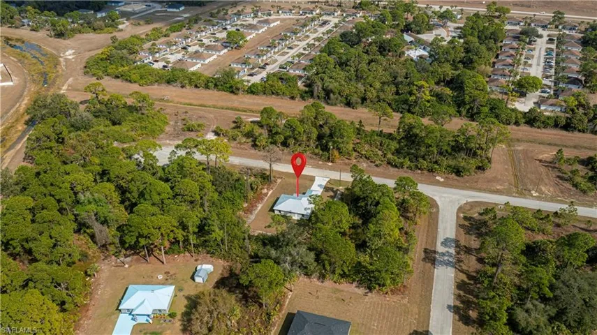 Aerial view of property and surrounding area with nearby suburban area