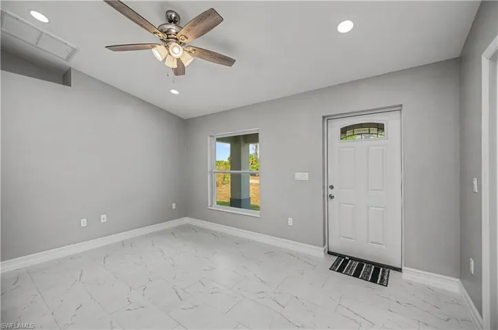 Foyer entrance featuring a ceiling fan, light marble finish flooring, recessed lighting, and lofted ceiling