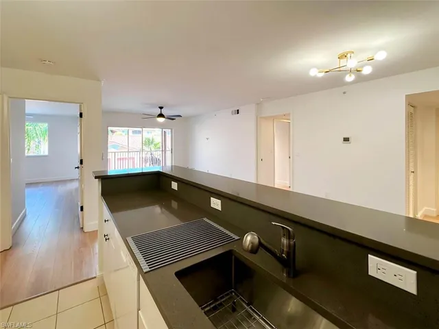 Kitchen featuring ceiling fan, light hardwood / wood-style floors, sink, and white cabinets