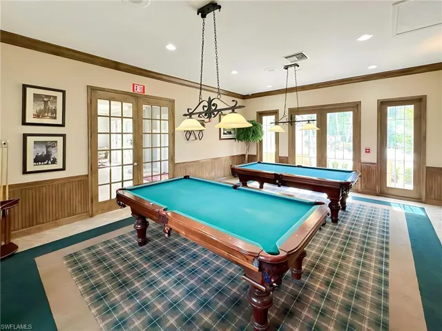 Rec room featuring french doors, wood walls, ornamental molding, and billiards