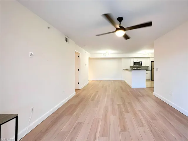 Unfurnished living room with light hardwood / wood-style floors and ceiling fan