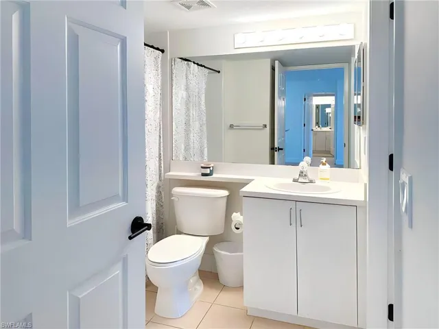 Bathroom with vanity, toilet, and tile patterned flooring