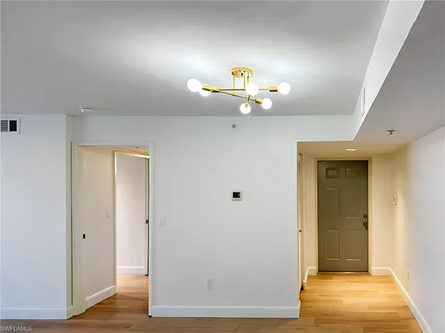 Unfurnished room with light hardwood / wood-style flooring and an inviting chandelier