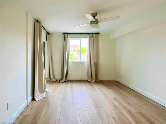 Empty room with light hardwood / wood-style floors and ceiling fan