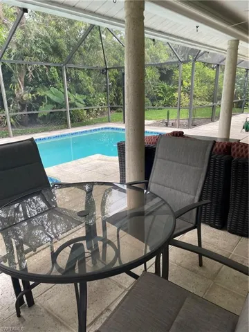 Pool with glass enclosure and a patio