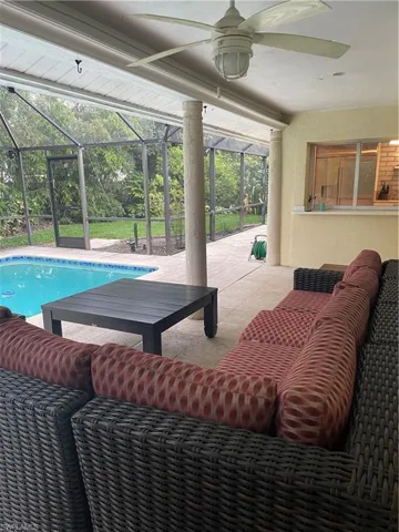Outdoor pool with glass enclosure, a patio, outdoor lounge area, and ceiling fan