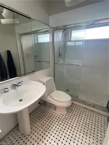 Full bath with toilet and a stall shower