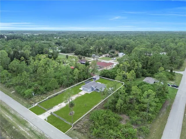 Aerial perspective highlighting a single-story residence with a light gray exterior and dark gray shingle roof