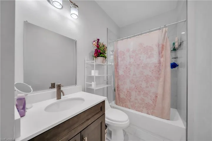Bathroom featuring a single vanity with a dark wood-finish cabinet, white countertop, and an undermount sink