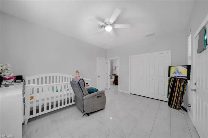 Spacious room featuring light gray walls and large-format tile flooring