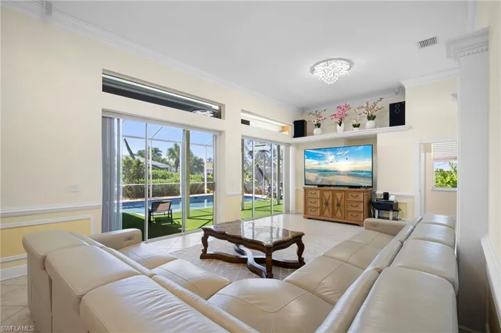 Living room with ornamental molding and light tile patterned flooring