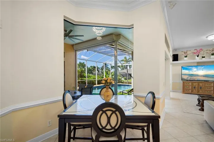 Dining space featuring a sunroom, ornamental molding, light tile patterned floors, and a ceiling fan