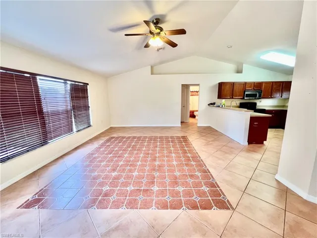 Living room featuring light tile patterned flooring with cathedral ceilings.
