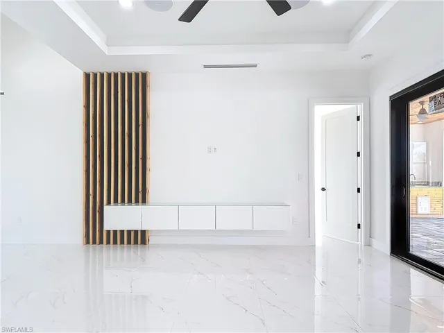 Unfurnished room featuring ceiling fan and a raised ceiling
