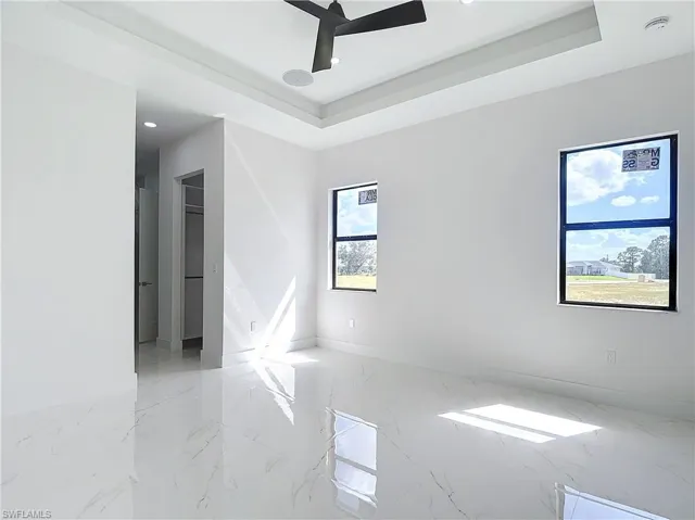 Spare room featuring ceiling fan and a raised ceiling
