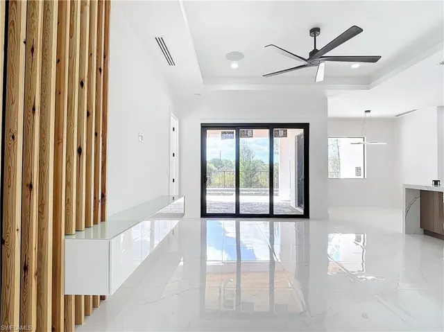Unfurnished room featuring ceiling fan and a tray ceiling